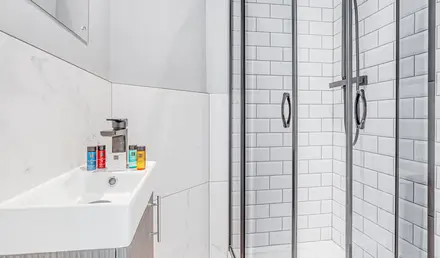 a shower with a sink and a towel on the side