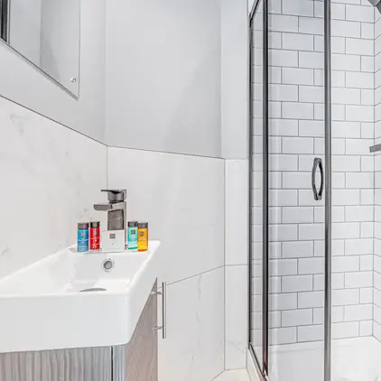 a shower with a sink and a towel on the side