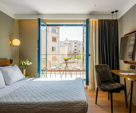 a bedroom with a bed and a desk and a television