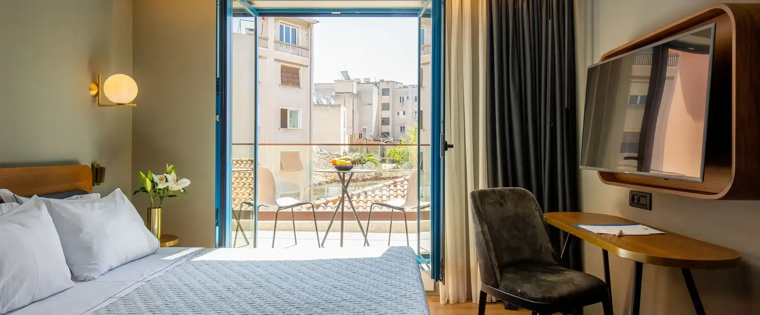 a bedroom with a bed and a desk and a television