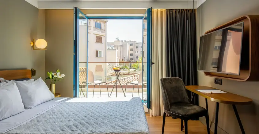 a bedroom with a bed and a desk and a television