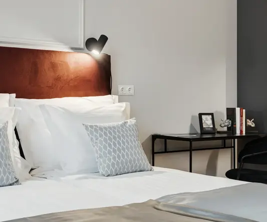 a bed with pillows and a desk