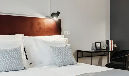 a bed with pillows and a desk