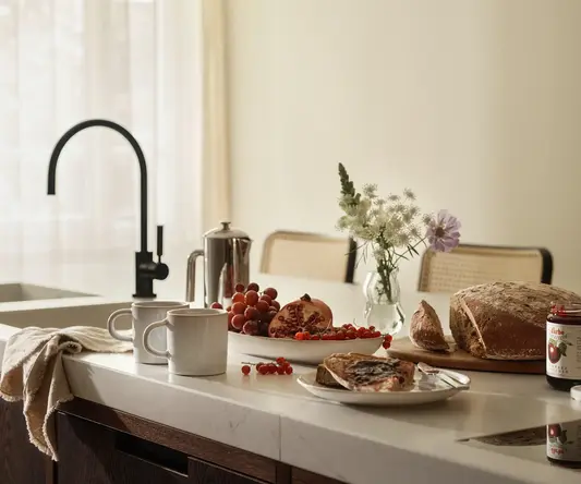 a kitchen counter with food and coffee cups
