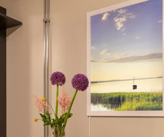 a table with a vase of flowers and a coffee maker on it