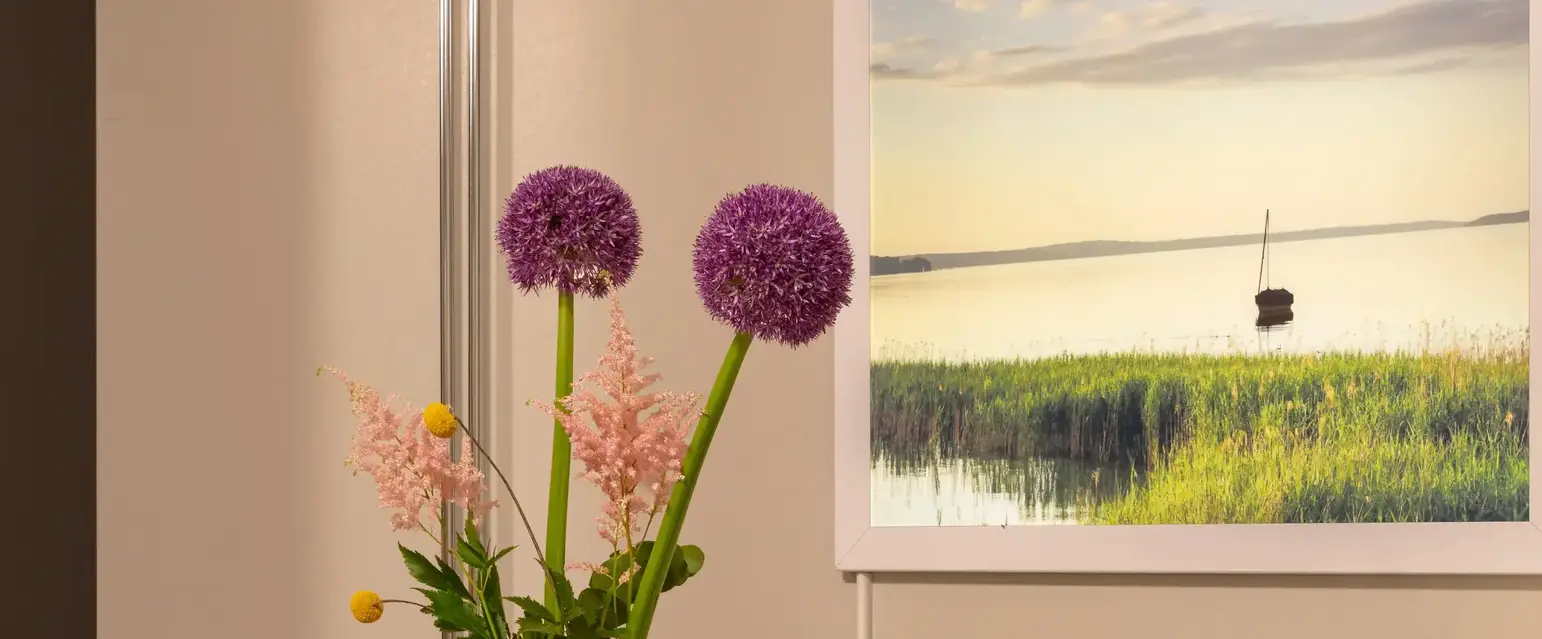 a table with a vase of flowers and a coffee maker on it