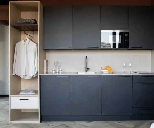 a kitchen with black cabinets and white counter tops