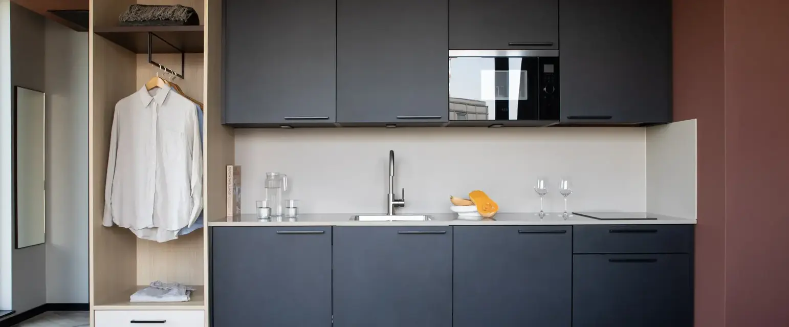 a kitchen with black cabinets and white counter tops