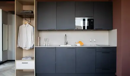 a kitchen with black cabinets and white counter tops