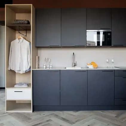 a kitchen with black cabinets and white counter tops