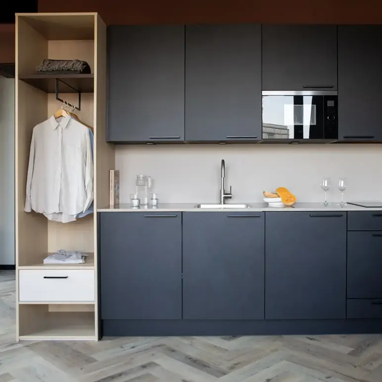 a kitchen with black cabinets and white counter tops