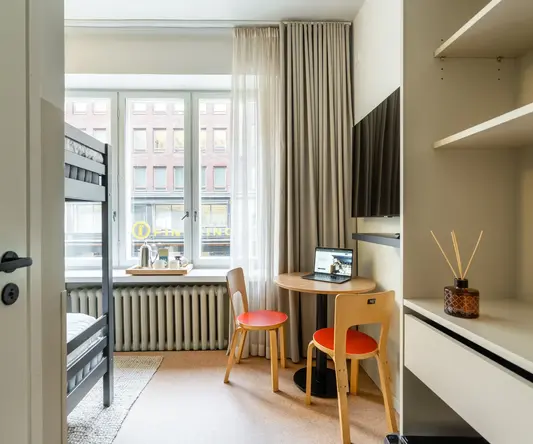 a small room with a desk and a bunk bed