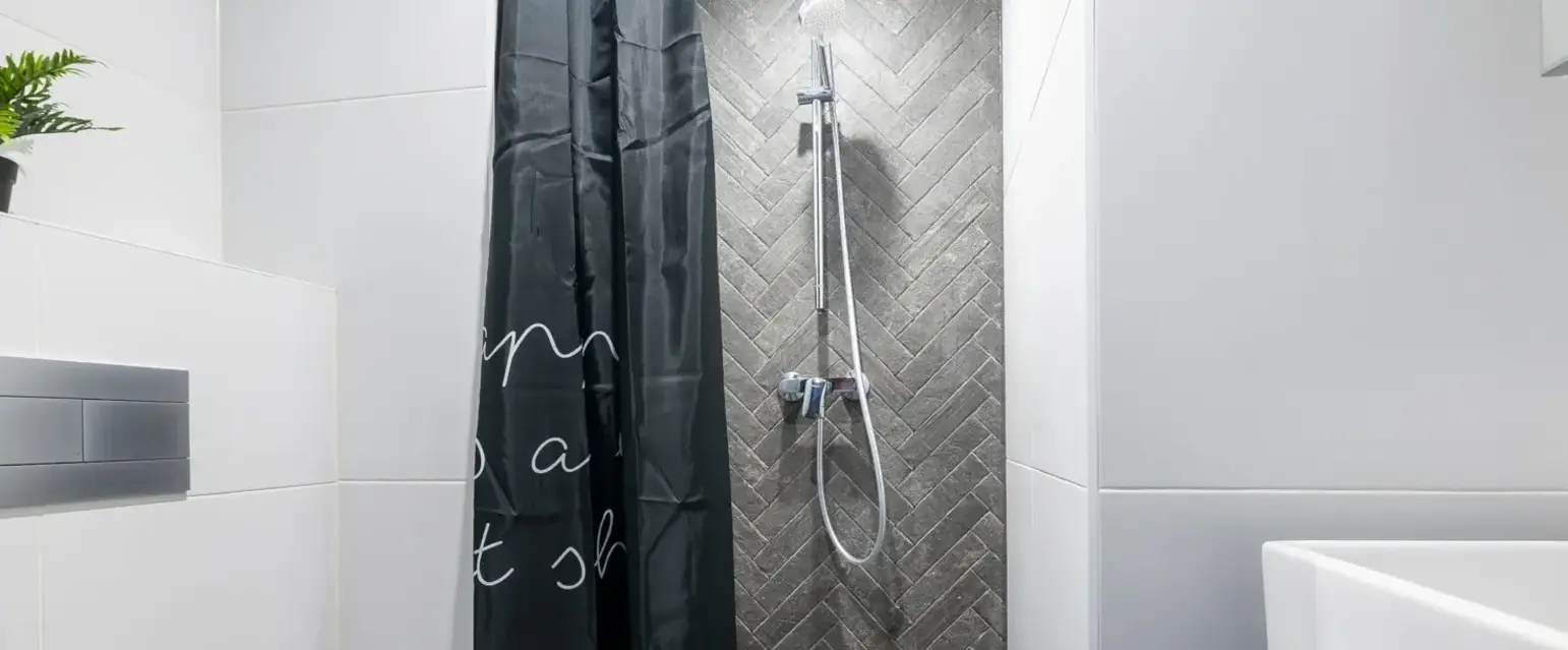 a shower with a black curtain