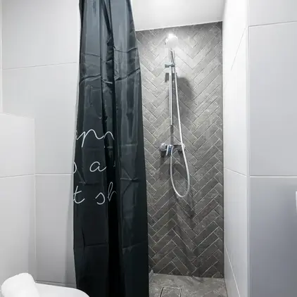 a shower with a black curtain
