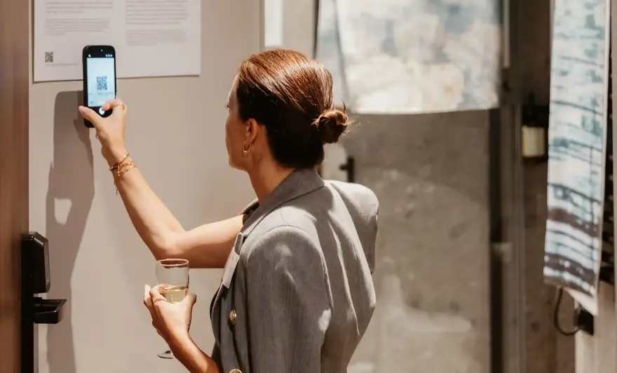 a woman holding a phone and drinking wine