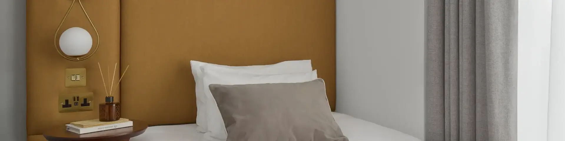 a bed with a brown headboard and a picture on the wall