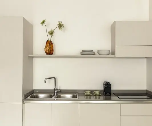 a kitchen with a sink and a sink and a vase of flowers