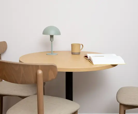 a table with a book and a lamp on it