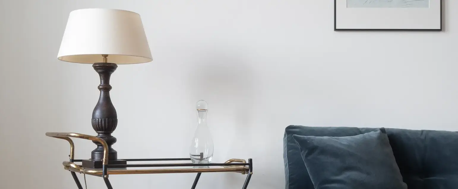 a blue couch with a lamp on a cart