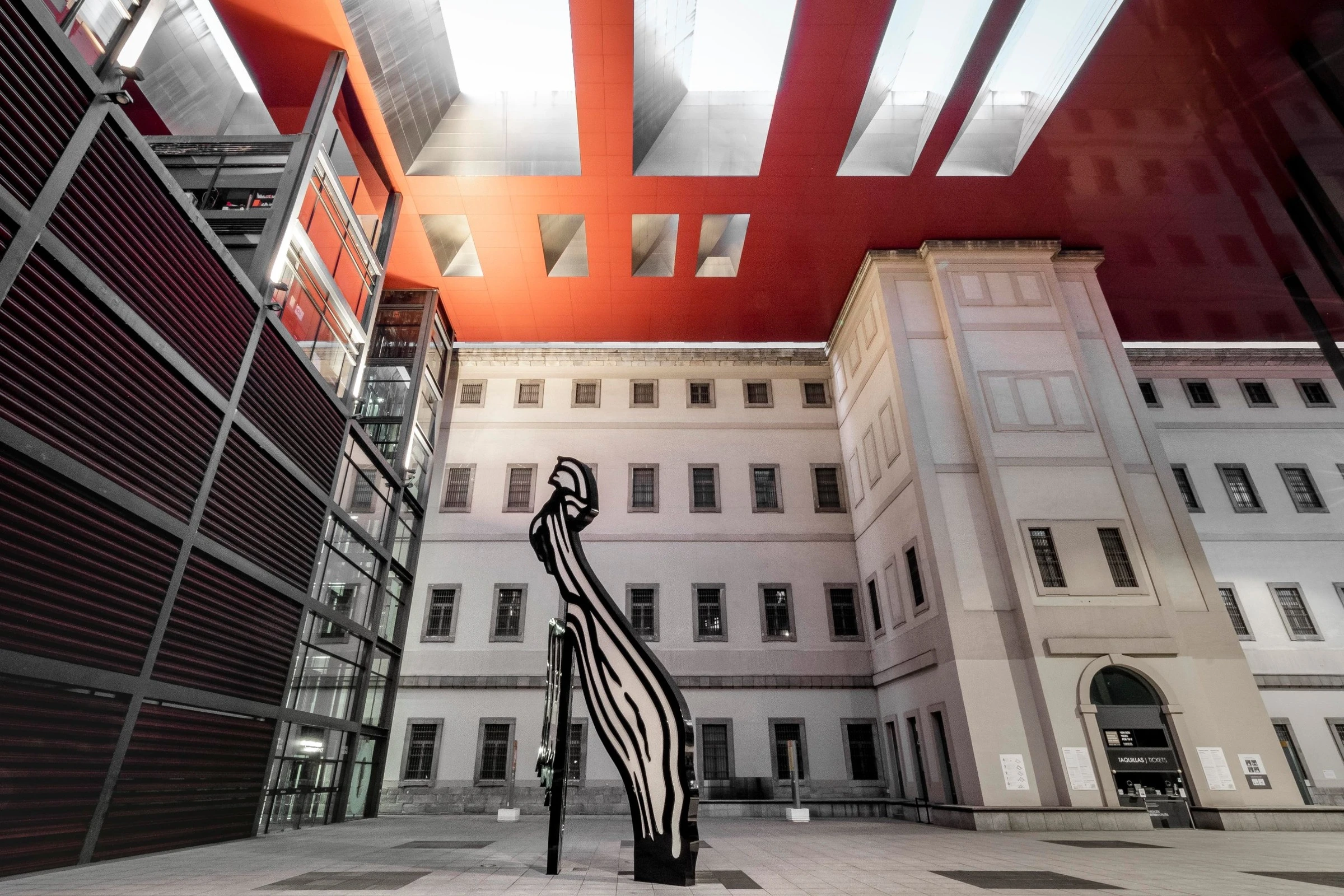 The red-canopied courtyard of the Reina Sofía with a large black-and-white sculpture in the foreground.