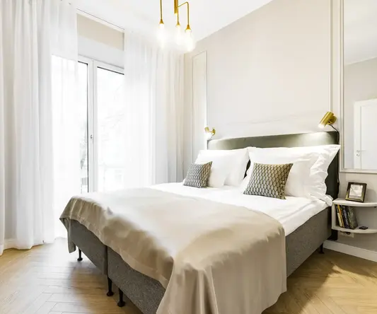 a bed with pillows and a light fixture