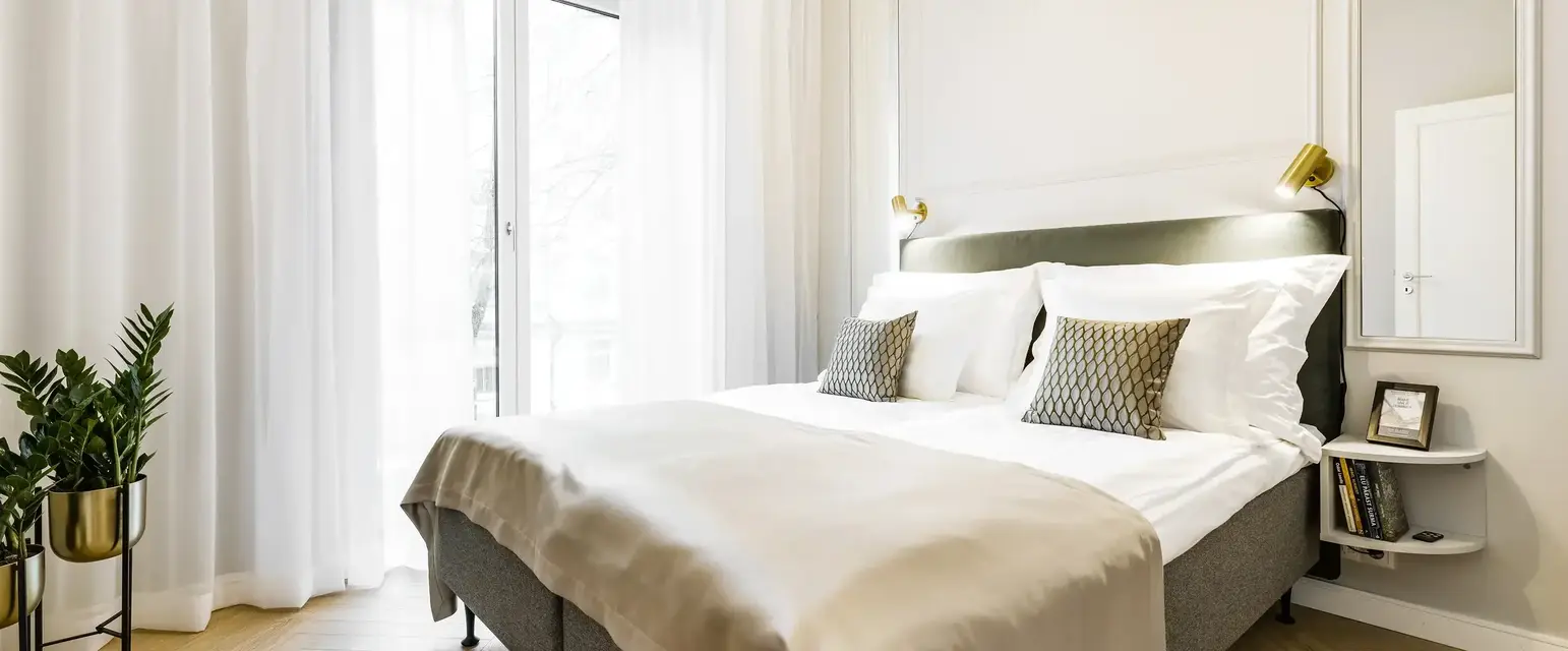 a bed with pillows and a light fixture