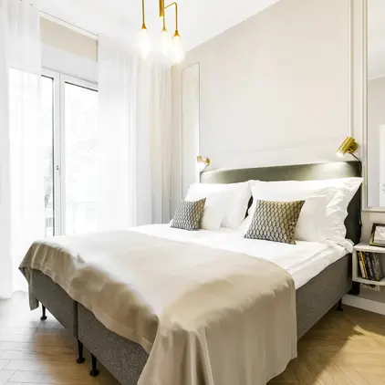 a bed with pillows and a light fixture