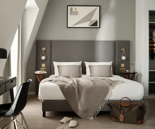 a bed with a blanket and a chair in a room