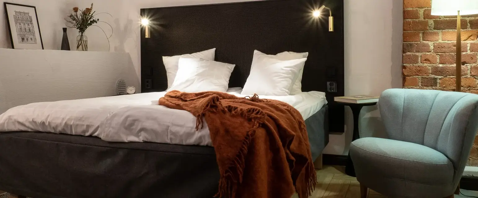 a bed with pillows and a chair in a room