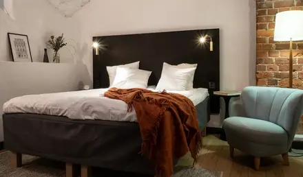 a bed with pillows and a chair in a room