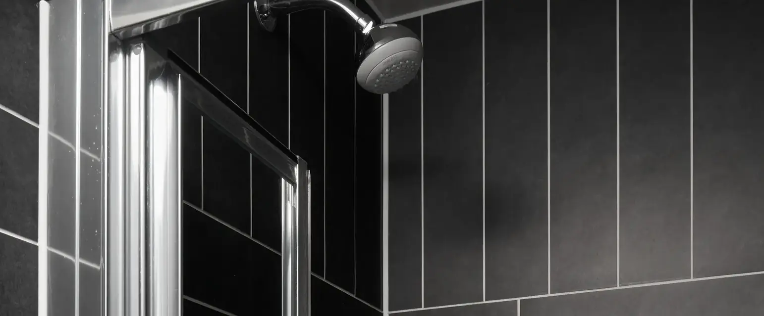 a shower with a shower head and bottles of liquid