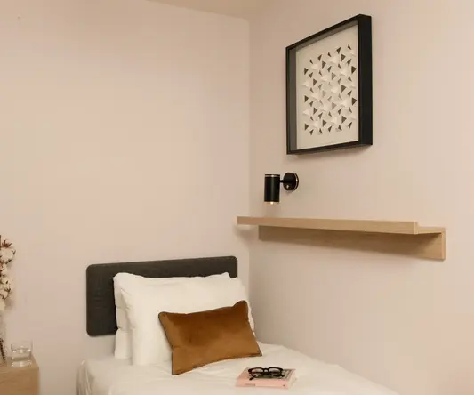a bed with a book and glasses on it