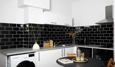 a kitchen with black tile walls and a black countertop