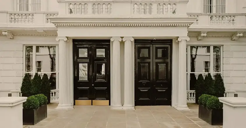 a building with columns and black doors