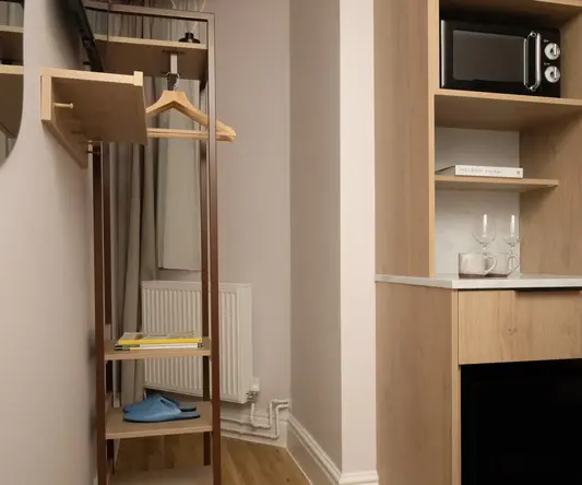 a room with a shelf and a microwave