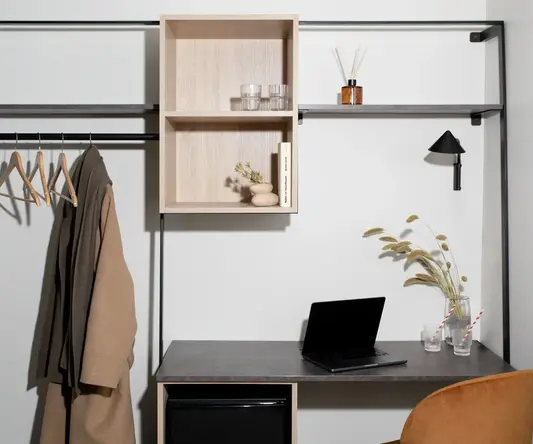 a desk with a laptop and shelves on it