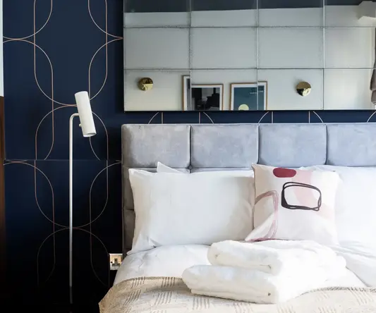 a bed with pillows and a mirror above it