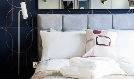 a bed with pillows and a mirror above it