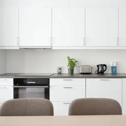 a kitchen with white cabinets and a table