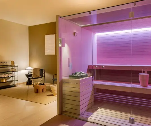 a glass wall inside a room with a pink sauna