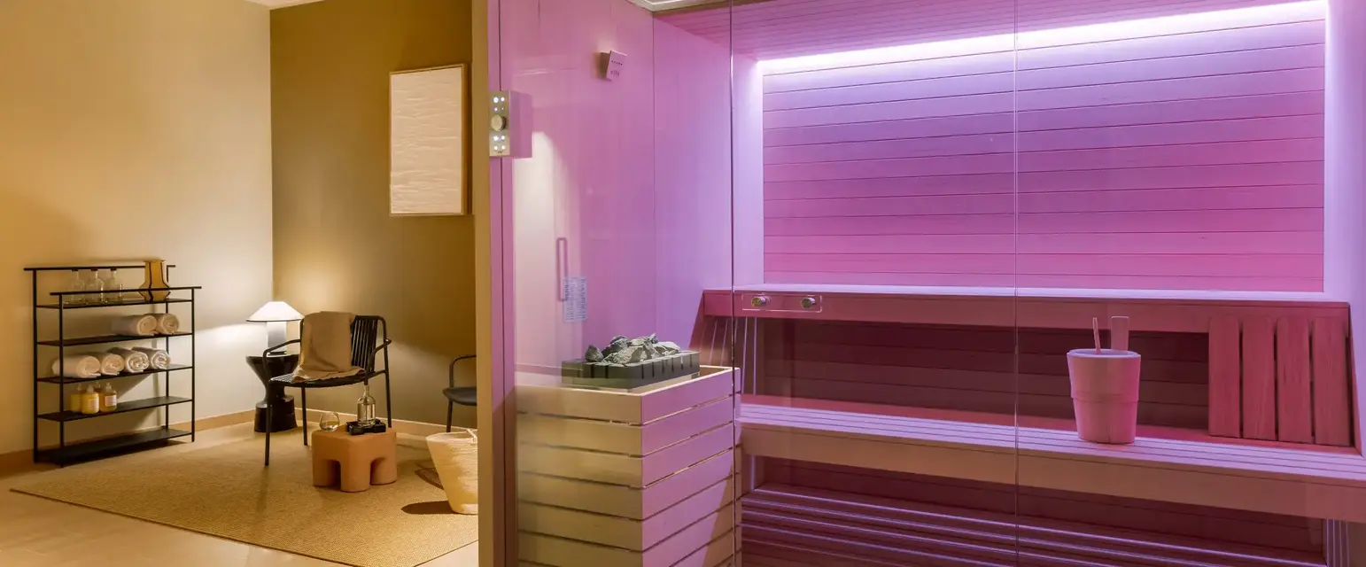 a glass wall inside a room with a pink sauna