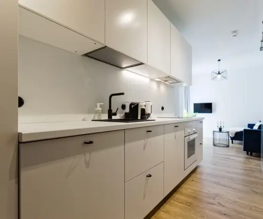 a kitchen with white cabinets and a couch