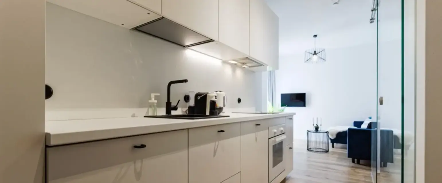 a kitchen with white cabinets and a couch
