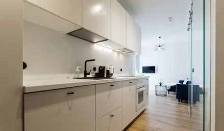 a kitchen with white cabinets and a couch