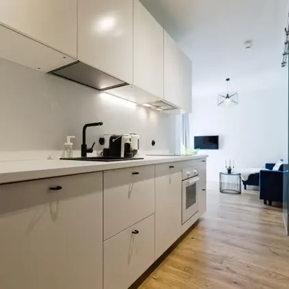 a kitchen with white cabinets and a couch